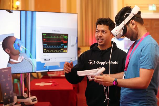 Azize Naji, founder of Goggleminds, demonstrates VR headset content to attendee
